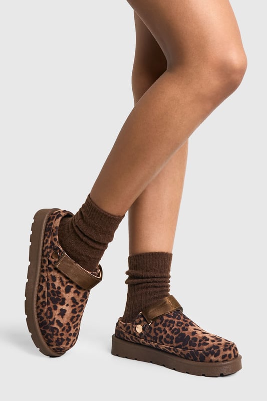 Eye-catching leopard print design
        Cosy mule style for easy slip-on wear
        Flat heel for all-day comfort (0-2cm height)
        Chunky sole for added durability
        Soft, plush lining for extra warmth
    
    Step into wild comfort with these trendy leopard print mules from Boohoo. Perfect for the fashion-forward woman who values both style and cosiness, these slip-ons are ideal for casual outings and relaxed days at home. The flat heel and chunky sole ensure stability and comfort, making them suitable for extended wear. Style them with your favourite loungewear for a chic at-home look, or pair them with cropped jeans and an oversized jumper for a quick coffee run. The versatile design allows for effortless transitioning from indoor relaxation to outdoor errands, embodying the perfect blend of fashion and functionality. Whether you're hosting a casual gathering or running weekend errands, these mules will keep you looking stylish and feeling comfortable throughout the day.