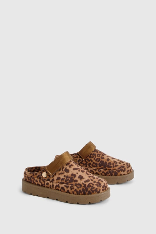 Eye-catching leopard print design
        Cosy mule style for easy slip-on wear
        Flat heel for all-day comfort (0-2cm height)
        Chunky sole for added durability
        Soft, plush lining for extra warmth
    
    Step into wild comfort with these trendy leopard print mules from Boohoo. Perfect for the fashion-forward woman who values both style and cosiness, these slip-ons are ideal for casual outings and relaxed days at home. The flat heel and chunky sole ensure stability and comfort, making them suitable for extended wear. Style them with your favourite loungewear for a chic at-home look, or pair them with cropped jeans and an oversized jumper for a quick coffee run. The versatile design allows for effortless transitioning from indoor relaxation to outdoor errands, embodying the perfect blend of fashion and functionality. Whether you're hosting a casual gathering or running weekend errands, these mules will keep you looking stylish and feeling comfortable throughout the day.