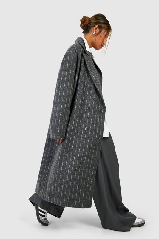 Oversized silhouette for a bold, contemporary look
        Classic pinstripe pattern adds sophistication
        Notched lapels and long sleeves for timeless appeal
        Versatile wool-look fabric suitable for various occasions
        Longline design for dramatic flair and extra warmth
    
    Make a striking statement with this pinstripe oversized coat, perfect for the fashion-forward individual who appreciates a blend of classic and modern styles. The generous cut allows for effortless layering over chunky knits or sleek tailoring, making it an ideal choice for transitional weather. Style it with wide-leg trousers and trainers for a chic, relaxed look, or pair it with a crisp white shirt and tailored trousers for more formal events. The timeless pinstripe pattern ensures this coat will remain a wardrobe staple for seasons to come, while its versatility allows for endless styling possibilities. Whether you're heading to the office, a smart-casual dinner, or a weekend brunch, this coat will keep you looking polished and on-trend.