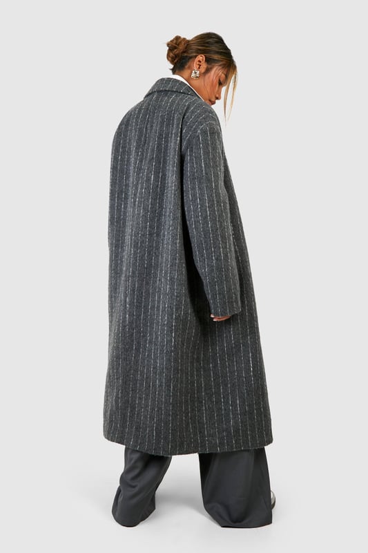 Oversized silhouette for a bold, contemporary look
        Classic pinstripe pattern adds sophistication
        Notched lapels and long sleeves for timeless appeal
        Versatile wool-look fabric suitable for various occasions
        Longline design for dramatic flair and extra warmth
    
    Make a striking statement with this pinstripe oversized coat, perfect for the fashion-forward individual who appreciates a blend of classic and modern styles. The generous cut allows for effortless layering over chunky knits or sleek tailoring, making it an ideal choice for transitional weather. Style it with wide-leg trousers and trainers for a chic, relaxed look, or pair it with a crisp white shirt and tailored trousers for more formal events. The timeless pinstripe pattern ensures this coat will remain a wardrobe staple for seasons to come, while its versatility allows for endless styling possibilities. Whether you're heading to the office, a smart-casual dinner, or a weekend brunch, this coat will keep you looking polished and on-trend.