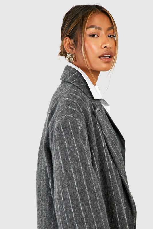Oversized silhouette for a bold, contemporary look
        Classic pinstripe pattern adds sophistication
        Notched lapels and long sleeves for timeless appeal
        Versatile wool-look fabric suitable for various occasions
        Longline design for dramatic flair and extra warmth
    
    Make a striking statement with this pinstripe oversized coat, perfect for the fashion-forward individual who appreciates a blend of classic and modern styles. The generous cut allows for effortless layering over chunky knits or sleek tailoring, making it an ideal choice for transitional weather. Style it with wide-leg trousers and trainers for a chic, relaxed look, or pair it with a crisp white shirt and tailored trousers for more formal events. The timeless pinstripe pattern ensures this coat will remain a wardrobe staple for seasons to come, while its versatility allows for endless styling possibilities. Whether you're heading to the office, a smart-casual dinner, or a weekend brunch, this coat will keep you looking polished and on-trend.