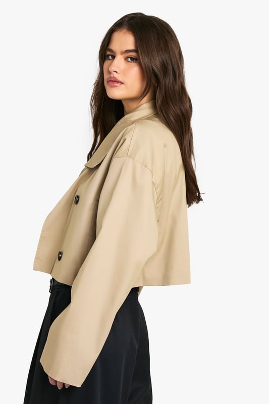 Chic cropped trench coat design
        Distinctive funnel collar for added style
        Double-breasted button fastening
        Wide, relaxed sleeves for a modern silhouette
        Versatile length perfect for layering
    
    This contemporary take on the classic trench coat is a must-have addition to your wardrobe. The cropped length and funnel collar create a fresh, youthful look that's perfect for the fashion-forward Boohoo girl. Style it with wide-leg trousers and a crisp white tee for a polished daytime ensemble. For a night out with the girls, throw it over a bodycon dress and pair with ankle boots. The relaxed fit allows for easy layering over jumpers when the temperature drops. Whether you're heading to uni, meeting friends for brunch, or enjoying a casual family gathering, this trench coat will keep you looking effortlessly stylish. Its versatility makes it an ideal choice for those impromptu plans that pop up in your busy social calendar.