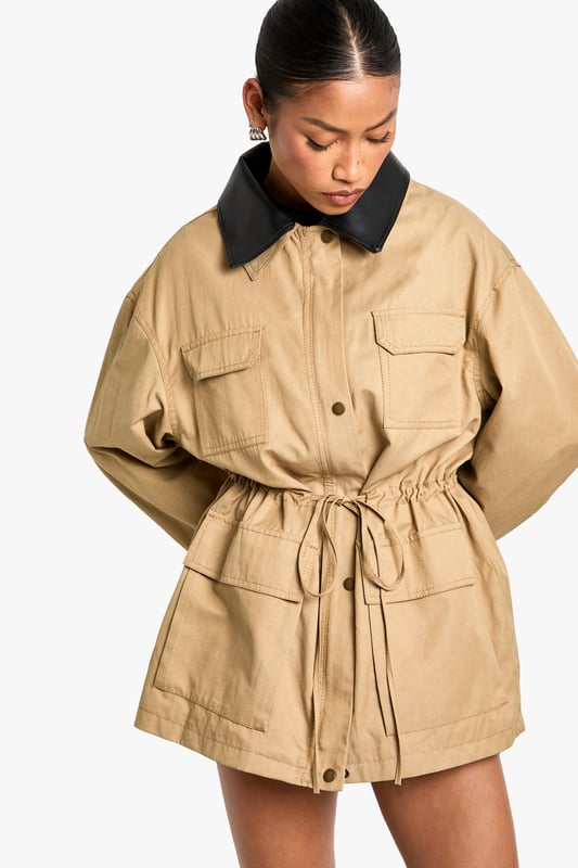 Striking contrast faux leather collar adds a contemporary edge to this utility-inspired jacket
        Practical front utility pockets perfect for keeping essentials close at hand
        Adjustable drawstring waist creates a flattering silhouette that can be cinched to preference
        Relaxed fit with dropped shoulders for effortless layering over jumpers and hoodies
        Button-through front closure with sturdy hardware details for added durability
    
    This versatile jacket with gathered waist detail combines practicality with on-trend style. The contrasting collar creates a distinctive look that works brilliantly for casual daytime outings. Style as seen with a simple black mini dress and knee-high boots for an effortlessly cool weekend ensemble, or pair with your favourite jeans and trainers for coffee dates and shopping trips. The adjustable waist allows you to customise the fit, creating either a more relaxed or defined silhouette depending on your mood. Perfect for unpredictable British weather, this jacket offers just the right amount of coverage for autumn strolls or spring evenings. The utility-inspired design makes it an ideal companion for family gatherings or casual meet-ups where comfort and style are equally important.