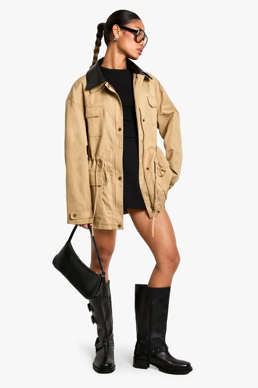 Striking contrast faux leather collar adds a contemporary edge to this utility-inspired jacket
        Practical front utility pockets perfect for keeping essentials close at hand
        Adjustable drawstring waist creates a flattering silhouette that can be cinched to preference
        Relaxed fit with dropped shoulders for effortless layering over jumpers and hoodies
        Button-through front closure with sturdy hardware details for added durability
    
    This versatile jacket with gathered waist detail combines practicality with on-trend style. The contrasting collar creates a distinctive look that works brilliantly for casual daytime outings. Style as seen with a simple black mini dress and knee-high boots for an effortlessly cool weekend ensemble, or pair with your favourite jeans and trainers for coffee dates and shopping trips. The adjustable waist allows you to customise the fit, creating either a more relaxed or defined silhouette depending on your mood. Perfect for unpredictable British weather, this jacket offers just the right amount of coverage for autumn strolls or spring evenings. The utility-inspired design makes it an ideal companion for family gatherings or casual meet-ups where comfort and style are equally important.