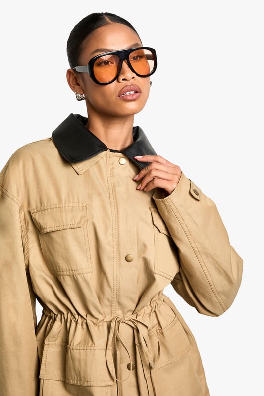 Striking contrast faux leather collar adds a contemporary edge to this utility-inspired jacket
        Practical front utility pockets perfect for keeping essentials close at hand
        Adjustable drawstring waist creates a flattering silhouette that can be cinched to preference
        Relaxed fit with dropped shoulders for effortless layering over jumpers and hoodies
        Button-through front closure with sturdy hardware details for added durability
    
    This versatile jacket with gathered waist detail combines practicality with on-trend style. The contrasting collar creates a distinctive look that works brilliantly for casual daytime outings. Style as seen with a simple black mini dress and knee-high boots for an effortlessly cool weekend ensemble, or pair with your favourite jeans and trainers for coffee dates and shopping trips. The adjustable waist allows you to customise the fit, creating either a more relaxed or defined silhouette depending on your mood. Perfect for unpredictable British weather, this jacket offers just the right amount of coverage for autumn strolls or spring evenings. The utility-inspired design makes it an ideal companion for family gatherings or casual meet-ups where comfort and style are equally important.