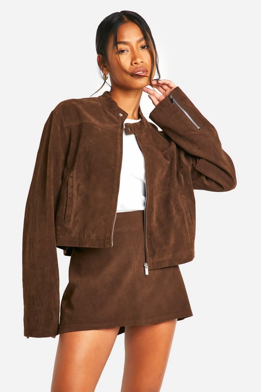 Faux suede jacket with zip-up front for easy wear
        Collarless design with a sleek, modern silhouette
        Long sleeves for versatile styling options
        Side pockets for practicality and hand warmth
        Cropped length perfect for pairing with high-waisted bottoms
    
    This faux suede jacket is a must-have addition to your casual wardrobe. Its soft texture and rich appearance lend a touch of luxury to any outfit, whilst maintaining a relaxed vibe. The zip-up front allows for effortless styling, whether fully fastened for a polished look or left open for a more laid-back feel. Pair it with a crisp white top and a matching mini skirt for a coordinated ensemble that's perfect for brunch with friends or a day of shopping. For a more casual approach, team it with your favourite jeans and trainers. The versatility of this jacket makes it ideal for family gatherings or casual outings. Its cropped length works wonderfully with high-waisted trousers or skirts, creating a balanced silhouette. Accessorise with statement earrings and a crossbody bag to complete your look. This Boohoo jacket embodies the brand's ethos of providing trendy, inclusive fashion that doesn't compromise on style or value.