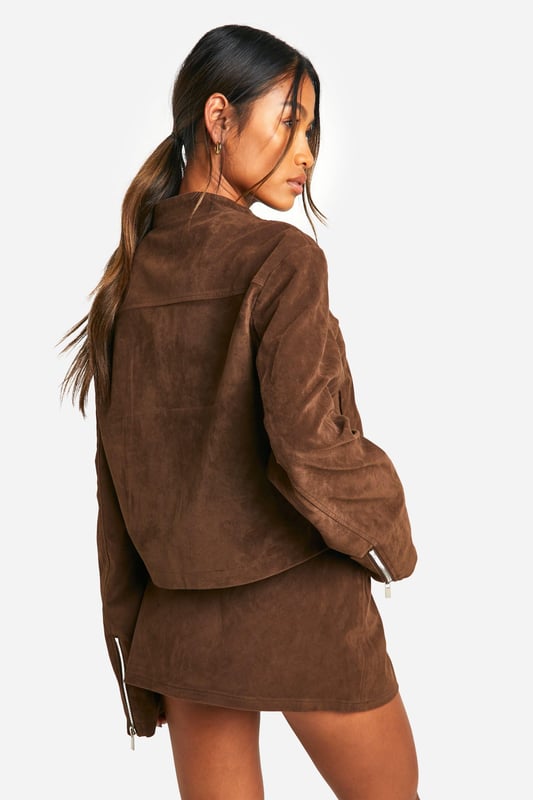 Faux suede jacket with zip-up front for easy wear
        Collarless design with a sleek, modern silhouette
        Long sleeves for versatile styling options
        Side pockets for practicality and hand warmth
        Cropped length perfect for pairing with high-waisted bottoms
    
    This faux suede jacket is a must-have addition to your casual wardrobe. Its soft texture and rich appearance lend a touch of luxury to any outfit, whilst maintaining a relaxed vibe. The zip-up front allows for effortless styling, whether fully fastened for a polished look or left open for a more laid-back feel. Pair it with a crisp white top and a matching mini skirt for a coordinated ensemble that's perfect for brunch with friends or a day of shopping. For a more casual approach, team it with your favourite jeans and trainers. The versatility of this jacket makes it ideal for family gatherings or casual outings. Its cropped length works wonderfully with high-waisted trousers or skirts, creating a balanced silhouette. Accessorise with statement earrings and a crossbody bag to complete your look. This Boohoo jacket embodies the brand's ethos of providing trendy, inclusive fashion that doesn't compromise on style or value.