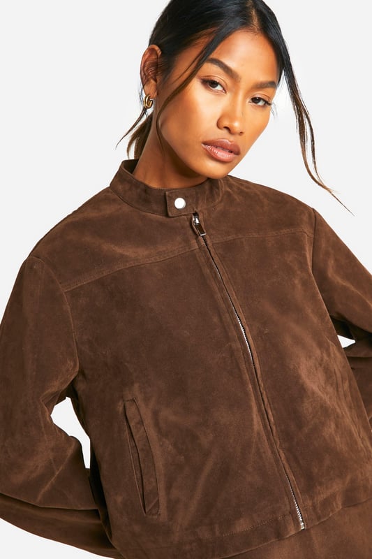 Faux suede jacket with zip-up front for easy wear
        Collarless design with a sleek, modern silhouette
        Long sleeves for versatile styling options
        Side pockets for practicality and hand warmth
        Cropped length perfect for pairing with high-waisted bottoms
    
    This faux suede jacket is a must-have addition to your casual wardrobe. Its soft texture and rich appearance lend a touch of luxury to any outfit, whilst maintaining a relaxed vibe. The zip-up front allows for effortless styling, whether fully fastened for a polished look or left open for a more laid-back feel. Pair it with a crisp white top and a matching mini skirt for a coordinated ensemble that's perfect for brunch with friends or a day of shopping. For a more casual approach, team it with your favourite jeans and trainers. The versatility of this jacket makes it ideal for family gatherings or casual outings. Its cropped length works wonderfully with high-waisted trousers or skirts, creating a balanced silhouette. Accessorise with statement earrings and a crossbody bag to complete your look. This Boohoo jacket embodies the brand's ethos of providing trendy, inclusive fashion that doesn't compromise on style or value.