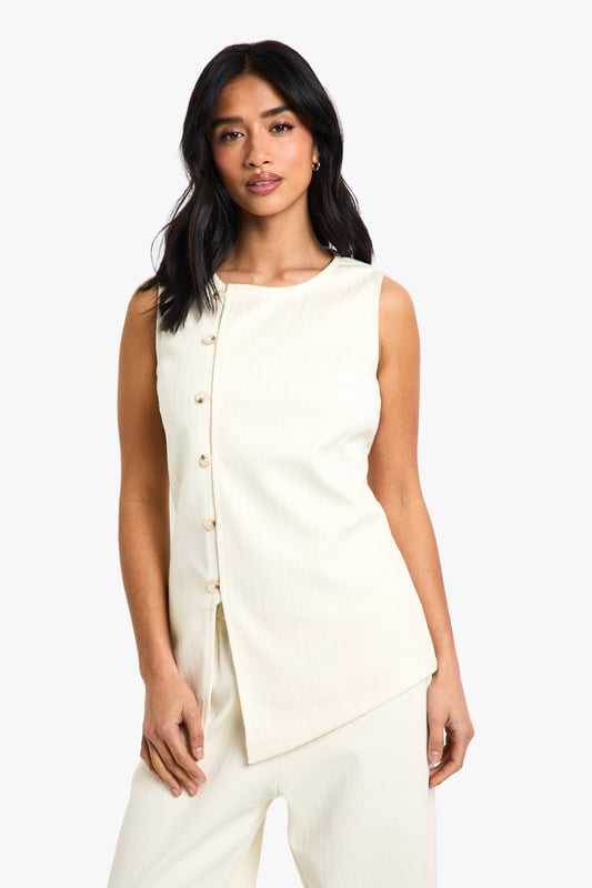 Sleeveless cord waistcoat with high neckline for a sophisticated silhouette
        Asymmetric button-through front detail adding contemporary flair
        Structured woven cotton fabric providing excellent shape retention
        Versatile petite fit designed specifically for smaller frames
        Sleek, clean-lined design perfect for layering or wearing alone
    
    This cord waistcoat reimagines a classic silhouette with modern asymmetric detailing, making it a standout piece for your evening wardrobe. The structured cotton fabric creates a flattering shape that works brilliantly for petite frames, whilst the high neckline adds a touch of sophistication. Style as seen with coordinating wide-leg trousers and pointed heels for a chic monochromatic ensemble that's perfect for drinks with the girls. For cooler evenings, layer over a fitted turtleneck or under a tailored blazer. Alternatively, dress it down with your favourite denim and trainers for casual drinks. The versatile design transitions effortlessly from day to night, making it an essential addition to your Boohoo collection that will see you through multiple social occasions with style and confidence.