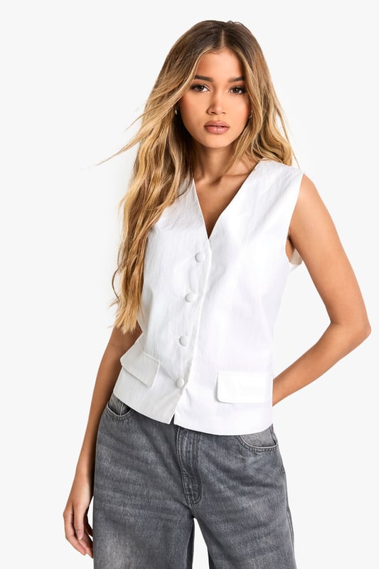 Sleek nylon vest with button-front closure
        V-neckline for a flattering silhouette
        Versatile sleeveless design
        Practical patch pockets at the waist
        Cropped length for a contemporary look
    
    Embrace effortless style with this chic nylon vest from Boohoo. Perfect for the fashion-forward woman who values both trend and versatility, this piece can easily transition from day to night. Layer it over a crisp white shirt and pair with wide-leg trousers for a polished office ensemble, or throw it on over a simple tee with your favourite jeans for a casual weekend look. The button-front closure and v-neckline add a touch of sophistication, while the cropped length keeps it current. Ideal for family gatherings or casual outings with friends, this vest is a wardrobe staple that can be dressed up or down with ease. Its lightweight nylon fabric makes it a practical choice for layering throughout the seasons, ensuring you stay on-trend whatever the weather.