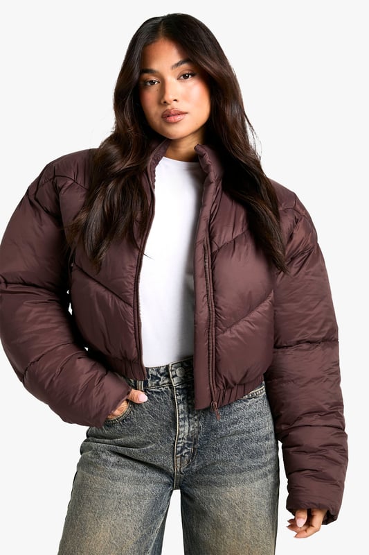 Cropped puffer jacket with funnel neck design
        Quilted pattern for added texture and warmth
        Full-length zip closure for easy wear
        Relaxed fit with dropped shoulders for a trendy silhouette
        Versatile piece suitable for various casual occasions
    
    Embrace the chilly weather in style with this petite steppjacke from Boohoo. The cropped silhouette and funnel neck design offer a contemporary twist on the classic puffer jacket, perfect for the fashion-forward woman who values both comfort and trend. Pair it with high-waisted jeans and chunky trainers for a laid-back weekend look, or throw it over a midi dress and boots for a chic contrast. The relaxed fit and dropped shoulders create a cool, effortless vibe that's ideal for casual outings, from coffee runs to shopping trips. This jacket is a must-have for your autumn/winter wardrobe, providing warmth without compromising on style. Its versatility makes it a go-to piece for family gatherings, outdoor events, or simply running errands in style.