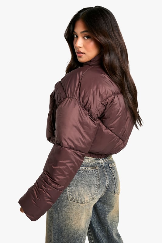 Cropped puffer jacket with funnel neck design
        Quilted pattern for added texture and warmth
        Full-length zip closure for easy wear
        Relaxed fit with dropped shoulders for a trendy silhouette
        Versatile piece suitable for various casual occasions
    
    Embrace the chilly weather in style with this petite steppjacke from Boohoo. The cropped silhouette and funnel neck design offer a contemporary twist on the classic puffer jacket, perfect for the fashion-forward woman who values both comfort and trend. Pair it with high-waisted jeans and chunky trainers for a laid-back weekend look, or throw it over a midi dress and boots for a chic contrast. The relaxed fit and dropped shoulders create a cool, effortless vibe that's ideal for casual outings, from coffee runs to shopping trips. This jacket is a must-have for your autumn/winter wardrobe, providing warmth without compromising on style. Its versatility makes it a go-to piece for family gatherings, outdoor events, or simply running errands in style.