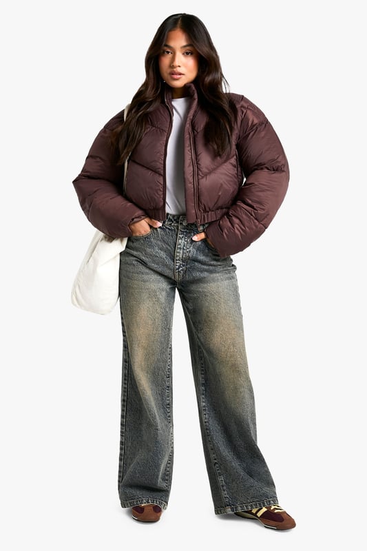 Cropped puffer jacket with funnel neck design
        Quilted pattern for added texture and warmth
        Full-length zip closure for easy wear
        Relaxed fit with dropped shoulders for a trendy silhouette
        Versatile piece suitable for various casual occasions
    
    Embrace the chilly weather in style with this petite steppjacke from Boohoo. The cropped silhouette and funnel neck design offer a contemporary twist on the classic puffer jacket, perfect for the fashion-forward woman who values both comfort and trend. Pair it with high-waisted jeans and chunky trainers for a laid-back weekend look, or throw it over a midi dress and boots for a chic contrast. The relaxed fit and dropped shoulders create a cool, effortless vibe that's ideal for casual outings, from coffee runs to shopping trips. This jacket is a must-have for your autumn/winter wardrobe, providing warmth without compromising on style. Its versatility makes it a go-to piece for family gatherings, outdoor events, or simply running errands in style.