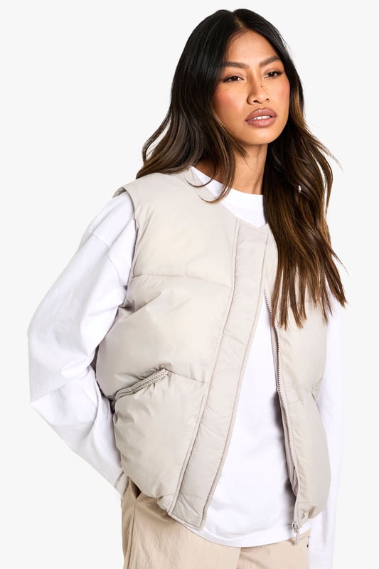 Sleeveless padded gilet with elegant bow detail at the back
        Practical side pockets for essentials and hand-warming
        Versatile round neckline that works with various tops
        Relaxed fit design perfect for layering
        Subtle quilted texture adding dimension to your outfit
    
    This Boohoo gilet offers the perfect blend of practicality and style for your casual wardrobe. The distinctive bow detail at the back transforms an everyday piece into something special, whilst maintaining its effortless wearability. Style as seen with a simple long-sleeved top and wide-leg trousers for a contemporary silhouette that works brilliantly for daytime outings. Add trainers and a baseball cap for an on-trend casual look, or dress up with ankle boots and statement jewellery for lunch with friends. The versatile design makes it ideal for transitional weather, providing just the right amount of warmth without bulk. Perfect for family gatherings, weekend shopping trips or casual coffee dates when you want to look stylish without trying too hard.