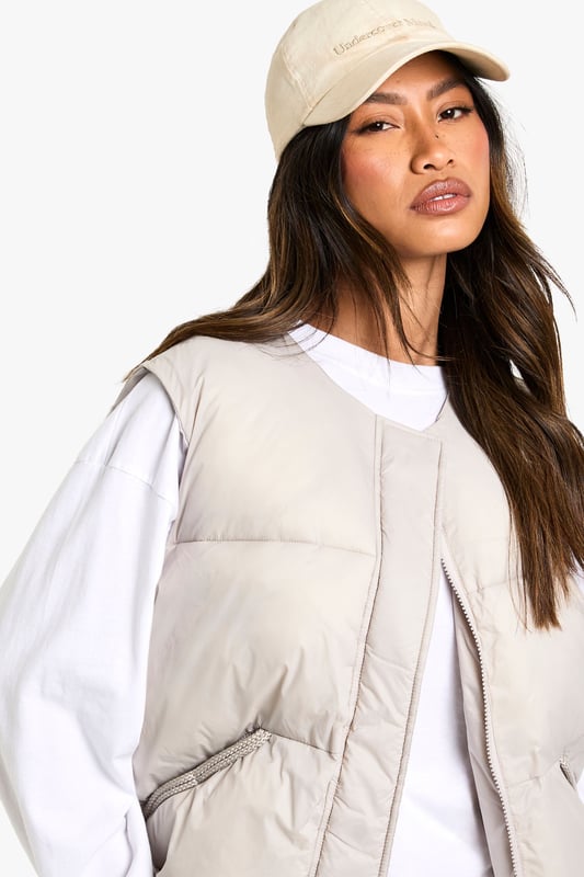 Sleeveless padded gilet with elegant bow detail at the back
        Practical side pockets for essentials and hand-warming
        Versatile round neckline that works with various tops
        Relaxed fit design perfect for layering
        Subtle quilted texture adding dimension to your outfit
    
    This Boohoo gilet offers the perfect blend of practicality and style for your casual wardrobe. The distinctive bow detail at the back transforms an everyday piece into something special, whilst maintaining its effortless wearability. Style as seen with a simple long-sleeved top and wide-leg trousers for a contemporary silhouette that works brilliantly for daytime outings. Add trainers and a baseball cap for an on-trend casual look, or dress up with ankle boots and statement jewellery for lunch with friends. The versatile design makes it ideal for transitional weather, providing just the right amount of warmth without bulk. Perfect for family gatherings, weekend shopping trips or casual coffee dates when you want to look stylish without trying too hard.