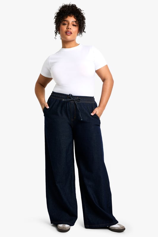 Straight-leg denim jeans with elastic waistband for comfort
        Wide-leg silhouette for a relaxed, on-trend look
        Convenient side pockets for practicality
        Drawstring detail at waist for adjustable fit
        Versatile design suitable for various casual occasions
    
    These plus-size jeans from Boohoo offer a perfect blend of style and comfort for the fashion-forward woman. The straight-leg cut and wide-leg silhouette create a flattering shape that's right on trend. The elastic waistband with drawstring detail ensures a customisable fit, making these jeans ideal for all-day wear. Style them with a crisp white tee and trainers for a laid-back daytime look, or dress them up with a fitted blouse and statement jewellery for casual evening events. The versatile denim fabric makes these jeans a wardrobe staple, easily transitioning from family gatherings to weekend brunches with friends. For a chic autumn ensemble, pair with a trench coat and ankle boots. These jeans embody Boohoo's commitment to inclusive fashion that doesn't compromise on style or comfort.