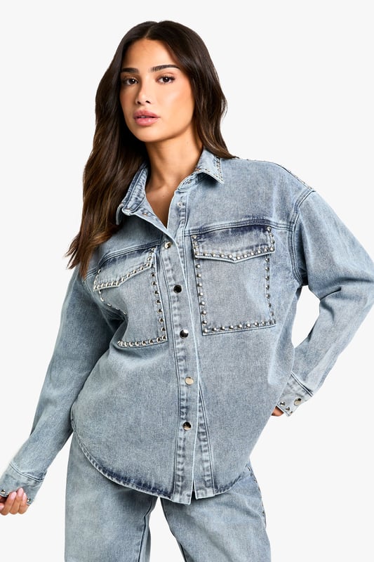 Oversized denim shirt featuring eye-catching stud detailing along the pockets
        Relaxed drop shoulder design for that effortlessly cool aesthetic
        Front button fastening with classic collar for versatile styling options
        Spacious chest pockets with distinctive stud embellishment
        Specially designed for petite frames whilst maintaining the trendy oversized silhouette
    
    This statement denim shirt combines casual comfort with edgy detailing, perfect for the fashion-forward woman who loves to make an impression. The oversized fit creates a relaxed silhouette that works brilliantly when paired with matching denim for a coordinated ensemble, as shown by our model. Layer over a simple vest top and team with wide-leg trousers for a contemporary daytime look, or half-tuck into high-waisted jeans for a more defined shape. The stud detailing adds a touch of attitude to casual gatherings and weekend brunches. For cooler days, style under an oversized blazer with trainers for an on-trend casual outfit, or dress up with ankle boots and statement jewellery for evening drinks. This versatile Boohoo piece transitions effortlessly from day to night whilst maintaining that coveted laid-back vibe.