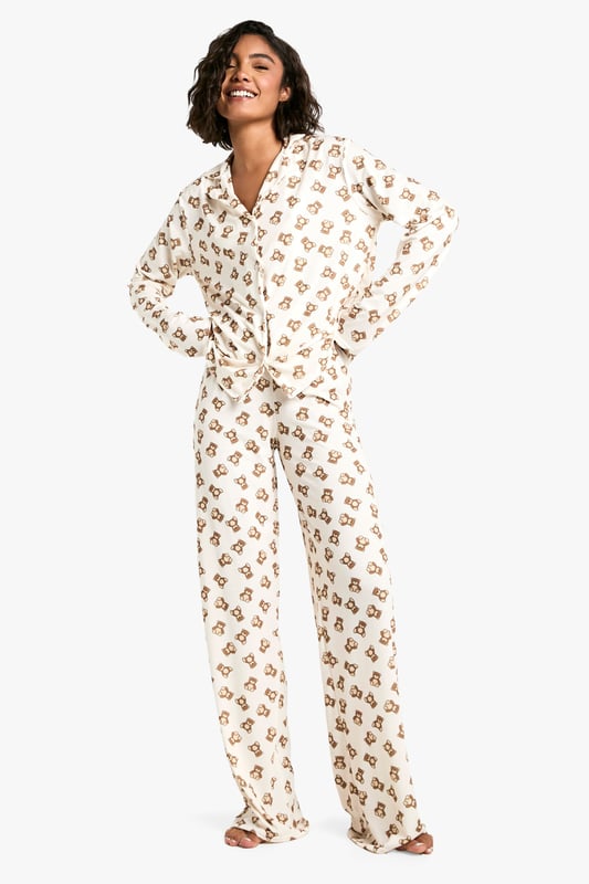 Charming bear print pyjama set
        Long-sleeved button-up top with notched collar
        Matching full-length trousers
        Soft jersey fabric for ultimate comfort
        Designed for tall frames
    
    Drift off to dreamland in style with this adorable bear print pyjama set from Boohoo. Perfect for those cosy nights in, this set combines comfort and charm effortlessly. The long-sleeved top features a classic button-up front and notched collar, while the full-length trousers ensure you stay snug from top to toe. Crafted from soft jersey fabric, it's designed to keep you comfortable throughout the night. The playful bear print adds a touch of whimsy to your nighttime routine, making bedtime something to look forward to. Ideal for lounging, late-night Netflix binges, or lazy weekend mornings, this pyjama set is versatile enough for year-round wear. For a complete nighttime ensemble, pair with fluffy slippers and a warm dressing gown for those chilly evenings. Whether you're treating yourself or looking for the perfect gift, this pyjama set is sure to delight any fashion-forward sleepyhead.