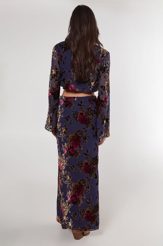 Striking floral devore pattern
        Maxi length for dramatic flair
        High-waisted design
        Side slit for ease of movement
        Coordinating crop top with bell sleeves
    
    Make a statement in this eye-catching floral devore maxi skirt from Nasty Gal. The intricate pattern adds depth and texture, while the maxi length creates a graceful silhouette. Perfect for daytime events, this skirt can be styled for various casual occasions. Pair it with the matching crop top as shown for a coordinated look, or mix it up with a plain fitted tee for a more relaxed vibe. The high-waisted design flatters the figure, while the side slit allows for comfortable movement. Complete the ensemble with ankle boots for a festival-ready outfit, or opt for flat sandals for a laid-back garden party. This versatile piece transitions effortlessly from family gatherings to casual brunches with friends, embodying the perfect blend of boho chic and contemporary style.
