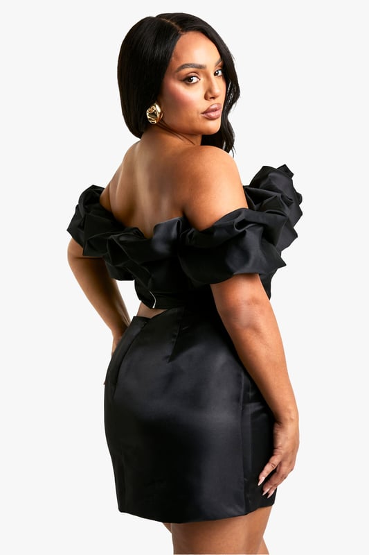 Bardot neckline with dramatic ruffle detailing
        Figure-hugging corset-style bodice
        Short, body-con silhouette
        Off-shoulder design for a sultry look
        Versatile piece suitable for various night-out occasions
    
    Make a statement in this eye-catching Bardot korsett top with ruffles. The off-shoulder design coupled with the voluminous ruffle detailing creates a captivating silhouette that's sure to turn heads. The corset-style bodice hugs your curves in all the right places, whilst the short length adds a flirty touch. Perfect for a night out on the town, this top pairs beautifully with high-waisted trousers or a sleek midi skirt. Add some strappy heels and statement earrings to complete your look. Whether you're headed to a trendy bar or dancing the night away at a club, this versatile piece will ensure you stand out from the crowd. The Boohoo Plus collection brings you the latest trends in sizes 16-24, allowing you to embrace your curves and express your style with confidence.