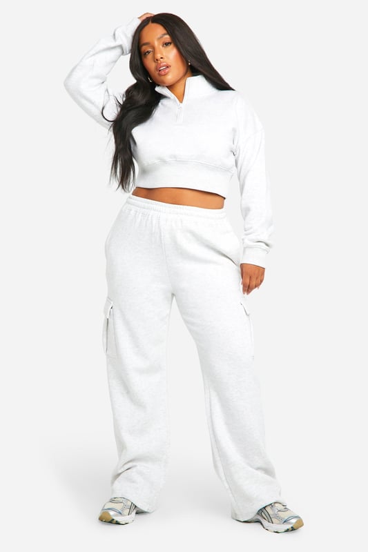 Cosy fleece-back fabric for ultimate comfort
        Cropped sweatshirt with ribbed collar and cuffs
        Straight-leg trousers with wrap-style waistband
        Convenient side pockets on trousers
        Versatile two-piece set for effortless styling
    
    Embrace laid-back chic with this Plus Sweatshirt and Straight Leg Trouser set from Boohoo. The cropped sweatshirt offers a trendy silhouette, while the straight-leg trousers with a unique wrap-style waistband add a contemporary twist to your casual wardrobe. Perfect for those lazy Sundays or running errands in style, this set is a must-have for the fashion-forward woman who values both comfort and trend-setting looks. Style it with chunky trainers and a crossbody bag for a cool, off-duty vibe, or dress it up with statement jewellery and sleek boots for a casual night out with friends. The versatility of this set makes it an ideal choice for various casual occasions, from family gatherings to weekend brunches, ensuring you look effortlessly stylish without compromising on comfort.