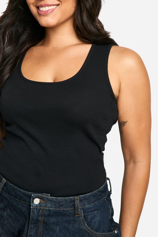 Ribbed jersey fabric for a comfortable, body-hugging fit
        Wide straps offer ample support and coverage
        Scoop neckline adds a feminine touch
        Versatile design suitable for layering or wearing alone
        Figure-flattering silhouette enhances curves
    
    This plus-size ribbed tank top from Boohoo is a wardrobe essential that combines style with comfort. The wide straps and scoop neckline create a flattering silhouette, while the ribbed jersey fabric ensures a snug fit that moves with you. Perfect for casual outings, this versatile piece can be styled in numerous ways. Pair it with high-waisted jeans and trainers for a relaxed daytime look, or dress it up with a midi skirt and statement jewellery for evening drinks with friends. Layer it under a blazer for a smart-casual office ensemble, or throw on a cardigan for family gatherings. The tank's adaptability makes it ideal for mixing and matching with various bottoms and accessories, allowing you to create multiple outfits for different occasions. Embrace your curves and feel confident in this chic, body-positive staple that's designed to complement your figure.