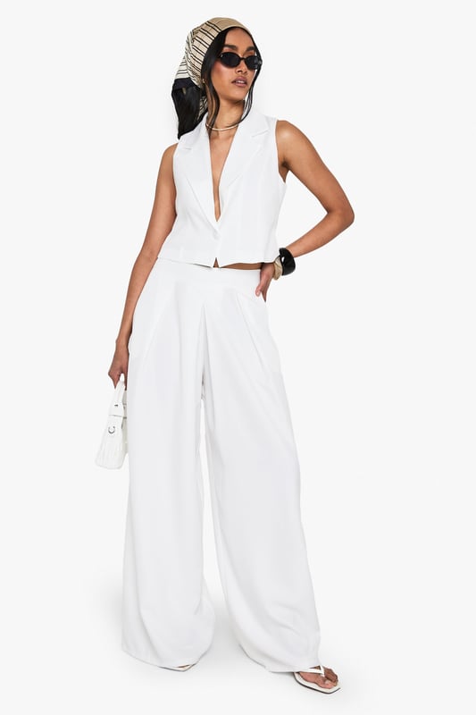 Wide leg silhouette for a relaxed, flowing fit
        High-waisted design with pleated front detail
        Sleek side pockets for practicality
        Cropped, sleeveless top with plunging neckline
        Versatile two-piece set for mix-and-match styling
    
    Make a statement in this chic wide-leg trouser set that combines comfort with urban sophistication. The high-waisted design elongates your silhouette, while the pleated front adds a touch of tailored elegance. Pair with the matching cropped top for a coordinated look that's perfect for a night out on the town. The plunging neckline of the top adds a daring edge, ideal for those looking to turn heads at the bar or club. For a more versatile approach, style the trousers with a fitted bodysuit and strappy heels, or dress down the top with high-waisted jeans for drinks with friends. This set is a must-have for the fashion-forward woman who values both style and comfort in her nightlife wardrobe. Accessorise with bold jewellery and a clutch bag to complete your going-out ensemble.