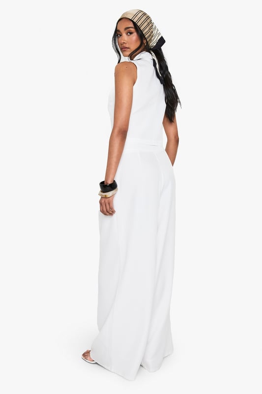 Wide leg silhouette for a relaxed, flowing fit
        High-waisted design with pleated front detail
        Sleek side pockets for practicality
        Cropped, sleeveless top with plunging neckline
        Versatile two-piece set for mix-and-match styling
    
    Make a statement in this chic wide-leg trouser set that combines comfort with urban sophistication. The high-waisted design elongates your silhouette, while the pleated front adds a touch of tailored elegance. Pair with the matching cropped top for a coordinated look that's perfect for a night out on the town. The plunging neckline of the top adds a daring edge, ideal for those looking to turn heads at the bar or club. For a more versatile approach, style the trousers with a fitted bodysuit and strappy heels, or dress down the top with high-waisted jeans for drinks with friends. This set is a must-have for the fashion-forward woman who values both style and comfort in her nightlife wardrobe. Accessorise with bold jewellery and a clutch bag to complete your going-out ensemble.