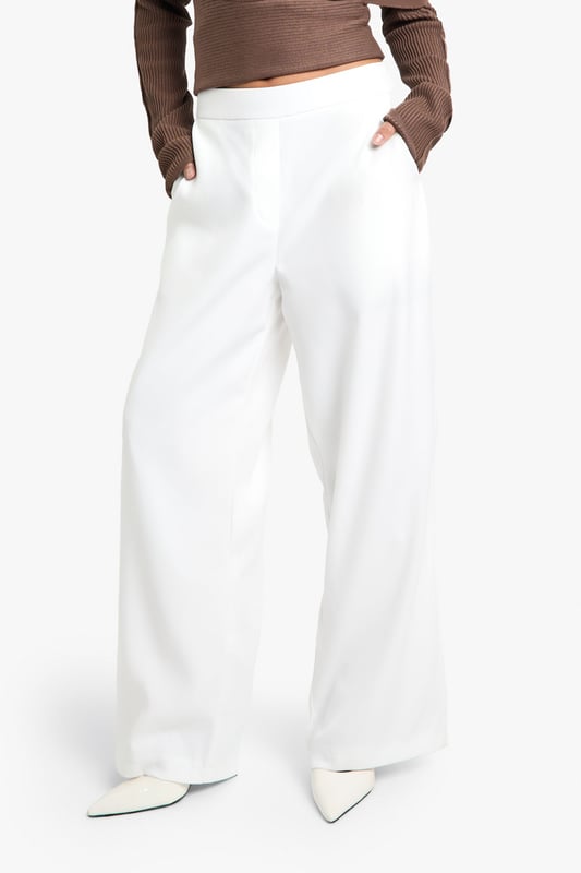 Straight leg trousers with distinctive waistband detail for a flattering silhouette
        Wide-leg design offering effortless movement and contemporary style
        Practical side pockets for convenience and functionality
        Smooth woven fabric with slight stretch for all-day comfort
        High-rise fit that pairs perfectly with cropped tops for night-out styling
    
    These statement trousers showcase a sophisticated waistband detail that creates a polished, put-together look for your evening adventures. The straight, wide-leg cut creates a dramatic silhouette that flows beautifully as you move, making them ideal for dancing the night away. Style with an off-shoulder top as shown for a balanced proportion that highlights the waistband feature. For a complete going-out ensemble, add pointed heels and a clutch bag for a look that transitions seamlessly from dinner to drinks. These versatile trousers work brilliantly for bar-hopping with friends or more upscale evening venues - simply adjust your accessories to suit the occasion. The clean lines and contemporary shape make these a wardrobe essential that will carry you through countless nights out with effortless style.