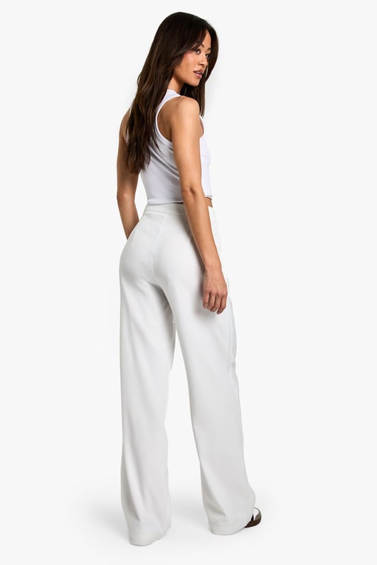 Designed specifically for taller frames with a flattering straight-leg silhouette
        Sleek waistband detail for a smooth, comfortable fit
        Practical side pockets for everyday essentials
        Versatile woven fabric with slight stretch for all-day comfort
        Wide-leg design creates a contemporary, fashion-forward look
    
    These sophisticated straight-leg trousers are the ultimate wardrobe essential for the fashion-forward woman. The clean lines and contemporary silhouette make them perfect for transitioning from day to night with effortless style. As seen on our model, pair with a simple crop top for a balanced look that showcases the high-waisted design, or add a structured blazer for more formal settings. The wide-leg cut creates a striking silhouette that works brilliantly with both trainers for casual daytime outings and heels for evening affairs. These trousers truly shine for going out occasions - whether you're heading to a trendy bar with friends or dancing the night away at a club. The slight stretch in the fabric ensures you'll remain comfortable whilst looking utterly chic throughout your evening adventures.