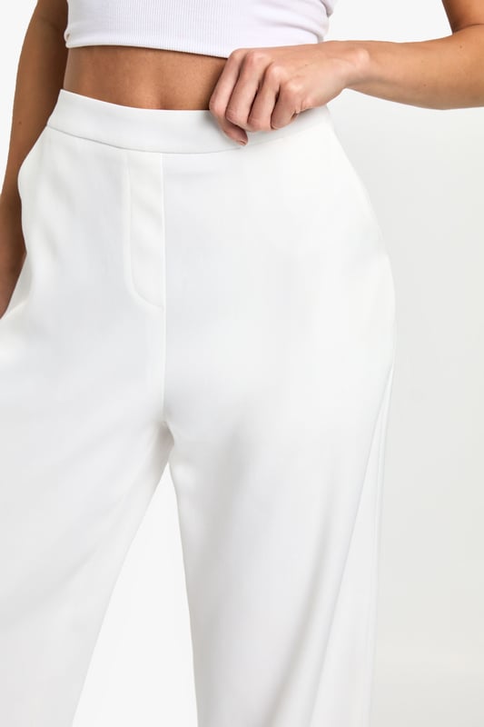 Designed specifically for taller frames with a flattering straight-leg silhouette
        Sleek waistband detail for a smooth, comfortable fit
        Practical side pockets for everyday essentials
        Versatile woven fabric with slight stretch for all-day comfort
        Wide-leg design creates a contemporary, fashion-forward look
    
    These sophisticated straight-leg trousers are the ultimate wardrobe essential for the fashion-forward woman. The clean lines and contemporary silhouette make them perfect for transitioning from day to night with effortless style. As seen on our model, pair with a simple crop top for a balanced look that showcases the high-waisted design, or add a structured blazer for more formal settings. The wide-leg cut creates a striking silhouette that works brilliantly with both trainers for casual daytime outings and heels for evening affairs. These trousers truly shine for going out occasions - whether you're heading to a trendy bar with friends or dancing the night away at a club. The slight stretch in the fabric ensures you'll remain comfortable whilst looking utterly chic throughout your evening adventures.