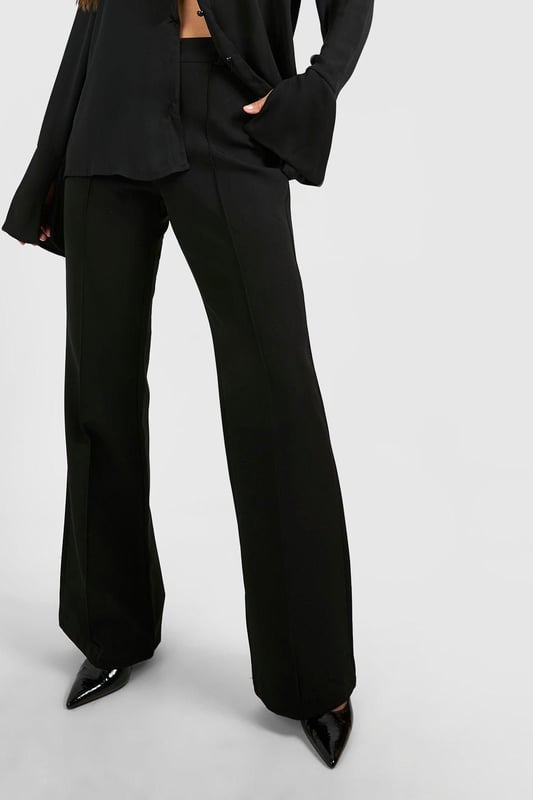 Flared leg design for a dramatic silhouette
        High-waisted fit accentuates the waistline
        Tailored construction for a polished look
        Stretchy bi-stretch fabric for comfort and movement
        Versatile style suitable for various occasions
    
    Make a statement with these eye-catching fit & flare tailored trousers from Boohoo. Perfect for the fashion-forward woman who loves to stand out, these trousers combine sophistication with a touch of drama. The high-waisted design elongates your legs, while the flared silhouette adds a bold, retro-inspired flair to your ensemble. Pair them with a cropped blazer and pointed-toe heels for a chic night out look, or dress them down with a fitted turtleneck and ankle boots for a stylish daytime outfit. The bi-stretch fabric ensures all-day comfort, allowing you to move with ease whether you're dancing the night away or navigating a busy day in the city. These trousers are a versatile addition to your wardrobe, easily transitioning from office to evening drinks with a simple change of accessories.