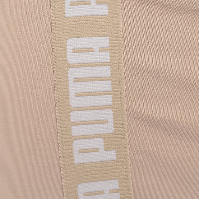 Main: 90% Polyester, Main: 10% Elastane. The Puma Training Strong crop top is a stylish and functional piece for your workout wardrobe. With its square neckline and stone-neutral color, it offers a chic look that doesn't sacrifice comfort or performance. The branding on the straps and band adds a bold touch, making it clear that you're wearing a piece designed for those who take their training seriously. Whether you're hitting the gym or just enjoying a casual day out, this crop top is sure to make a statement.