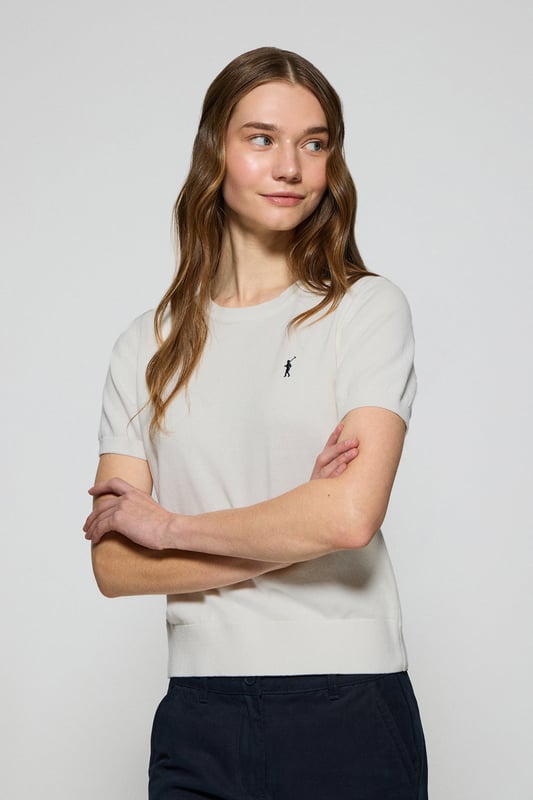 Dieser kurzärmlige Damenstrickpullover ist die perfekte Kombination aus Eleganz und Komfort. Er ist aus weicher Baumwolle gefertigt und hat eine reguläre Passform, die sich sanft an die Silhouette anschmiegt. Der Rundhalsausschnitt und die gerippten Abschlüsse an den Ärmeln, am Kragen und am Bund sorgen für einen bequemen Sitz. Das marineblaue Nahtband am Kragen mit Polo Club Logo unterstreicht die Eleganz dieses Modells. Das emblematische Rigby Go Logo in Kontrastfarbe auf der Brust unterstreicht seine einzigartige Optik. Ideal allein getragen der in Kombination mit unserer geknöpften Strickjacke.