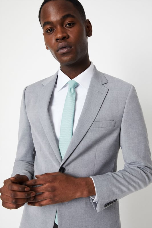 Introducing our Skinny Fit Essential Smart Jacket, perfect for any occasion. This jacket features a 2 button closure and a notch lapel, giving it a classic and timeless look. The twin back vent allows for ease of movement and added comfort. Made with a polyester viscose blend fabric with added stretch, to ensure a cool and comfortable fit all day long. Whether you're dressing up for a formal event or adding a touch of sophistication to your everyday look, our Skinny Fit Essential Smart Jacket is the perfect choice.