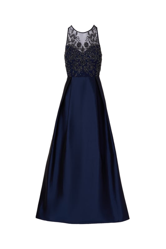 A pinnacle of glamor, youll love getting dressed up in this sleeveless ball gown. The bodice of this exquisite gown is adorned with an all-over beaded embellished mesh knit fabric, catching the light with every step. A crew neckline and illusion sweetheart bodice add sophistication and allure, while the flowing taffeta skirt exudes luxury and grace. Finished with a discreet zipper at the center back, this gown ensures a flawless fit and effortless movement, making it perfect for black-tie events where timeless style and sophistication are essential.