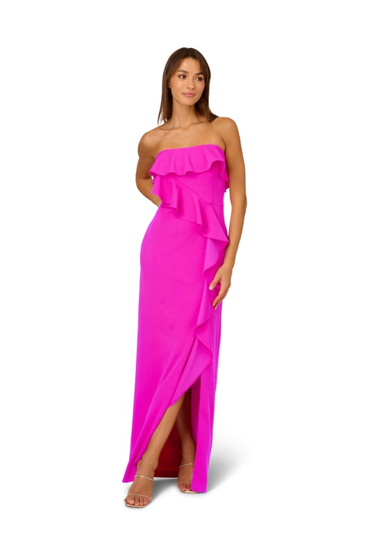 A lovely cascade of ruffles lend feminine charm to this strapless gown. This formal dress features a strapless bodice, column skirt with slit at the side, and ruffle trim that adorns the neckline and drapes elegantly across and down the gown. Crafted from knit crepe fabric with comfortable stretch, this strapless gown will be a showstopper for formal and black-tie affairs. A zipper closure at the center back completes this elegant dress. Styled with gold accessories and a beaded clutch, you are ready for any invite that comes your way.
