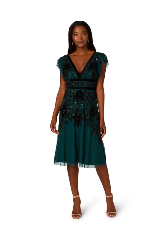 Elevate your evening attire with our stunning midi dress, crafted from an exquisite all-over beaded mesh knit fabric. The V-neckline at both front and back creates a flattering silhouette, complemented by delicate flutter sleeves for a touch of femininity. Velvet trim detailing at the neckline and waist adds luxurious contrast, while the zipper closure at the centre back ensures a seamless fit. Perfect for formal occasions or special events, this dress effortlessly combines elegance and allure, making it a standout choice for any sophisticated affair.
