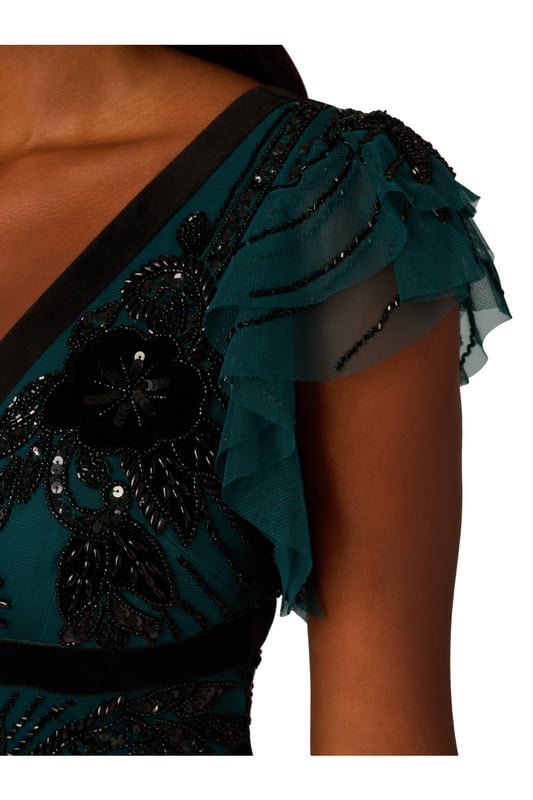 Elevate your evening attire with our stunning midi dress, crafted from an exquisite all-over beaded mesh knit fabric. The V-neckline at both front and back creates a flattering silhouette, complemented by delicate flutter sleeves for a touch of femininity. Velvet trim detailing at the neckline and waist adds luxurious contrast, while the zipper closure at the centre back ensures a seamless fit. Perfect for formal occasions or special events, this dress effortlessly combines elegance and allure, making it a standout choice for any sophisticated affair.