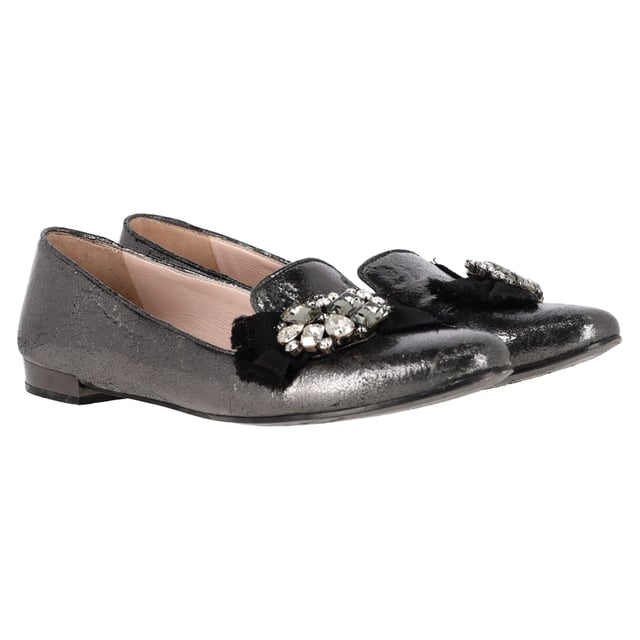 VINTAGE, UVP WIE NEU  
Die Miu Miu von Prada Jeweled Ballerinas aus metallic grauem Leder bieten eine perfekte Fusion aus Komfort und hochwertiger Mode, mit ausgefeilten, mit Edelsteinen besetzten Details für einen Hauch von Luxus. Hergestellt aus weichem metallic grauem Leder, sind diese Ballerinas vielseitig genug, um jedes Outfit zu erhöhen und gleichzeitig ganztägliche Tragbarkeit zu bieten. Kombinieren Sie sie mit einem fließenden Midikleid für einen schicken, femininen Look, oder stylen Sie sie mit maßgeschneiderten Hosen und einer Bluse für eine elegante, raffinierte Ausstrahlung. Der metallische Glanz verleiht einen zeitgemäßen Akzent und macht sie zu einem Statement-Stück, das sowohl zu legerer als auch zu abendlicher Kleidung passt.

Miu Miu von Prada Jeweled Ballerinas aus metallic grauem Leder

Zustand: Sehr gut  
Abnutzungserscheinungen: Einschließlich Box. Leichte Markierungen, Leicht gebraucht, aber sehr gut gepflegt. Kleine Abnutzungsspuren an den Sohlen & Falten, leichte Kratzer an den Sohlen und Fersen.  
Verpackung: Box  
Farbe: Grau  
Material: Leder | Leder  
Größe: IT | 41  
Maßnahmen: Innensohlenlänge: 300  
SKU: NAPPUGBSH465050W