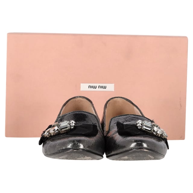 VINTAGE, UVP WIE NEU  
Die Miu Miu von Prada Jeweled Ballerinas aus metallic grauem Leder bieten eine perfekte Fusion aus Komfort und hochwertiger Mode, mit ausgefeilten, mit Edelsteinen besetzten Details für einen Hauch von Luxus. Hergestellt aus weichem metallic grauem Leder, sind diese Ballerinas vielseitig genug, um jedes Outfit zu erhöhen und gleichzeitig ganztägliche Tragbarkeit zu bieten. Kombinieren Sie sie mit einem fließenden Midikleid für einen schicken, femininen Look, oder stylen Sie sie mit maßgeschneiderten Hosen und einer Bluse für eine elegante, raffinierte Ausstrahlung. Der metallische Glanz verleiht einen zeitgemäßen Akzent und macht sie zu einem Statement-Stück, das sowohl zu legerer als auch zu abendlicher Kleidung passt.

Miu Miu von Prada Jeweled Ballerinas aus metallic grauem Leder

Zustand: Sehr gut  
Abnutzungserscheinungen: Einschließlich Box. Leichte Markierungen, Leicht gebraucht, aber sehr gut gepflegt. Kleine Abnutzungsspuren an den Sohlen & Falten, leichte Kratzer an den Sohlen und Fersen.  
Verpackung: Box  
Farbe: Grau  
Material: Leder | Leder  
Größe: IT | 41  
Maßnahmen: Innensohlenlänge: 300  
SKU: NAPPUGBSH465050W