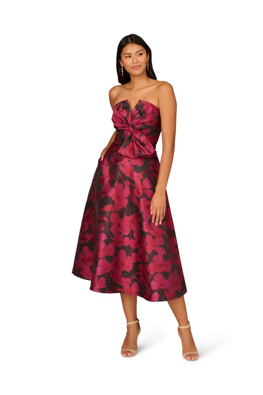 Make a stunning entrance in this strapless midi dress. This cocktail dress features a bow-trimmed bodice, a strapless neckline with notched cutout, and a full midi skirt with pockets. Designed with floral jacquard fabric from China, this fit and flare dress is a classic look that has been elevated with modern details. A hidden zipper back closure completes this floral party dress. Accessorized with heels and your favourite clutch, this strapless party dress is bound to shine for years to come.