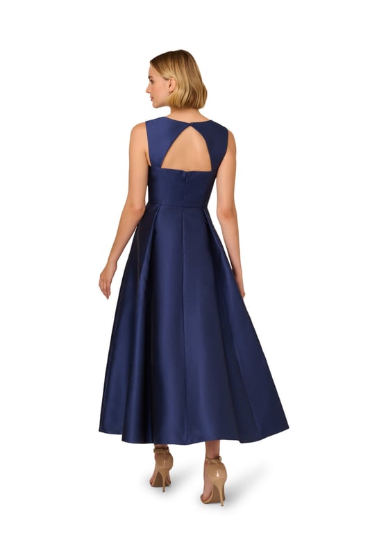 Classic elegance in a garment, this ankle-length sleeveless dress is constructed in crisp and lustrous Mikado fabric. Tailored details harken back to 50s couture with a sweetheart neckline and fit and flare silhouette. The back features a wide cutout at the top for a modern touch. A back zipper and side pockets finish the look.