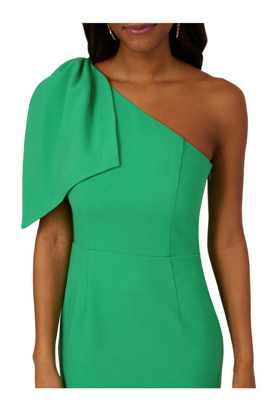 Own every room you walk into in this timeless midi dress. This chic dress features a one shoulder neckline, fitted body, and a mid-length skirt. Crafted from crepe fabric, this cocktail dress has a large bow accent at the shoulder. A zipper closure and slit at the centre back of this midi dress complete the design. Accessorize with your favourite heels and statement earrings for a look that will shine no matter the occasion.