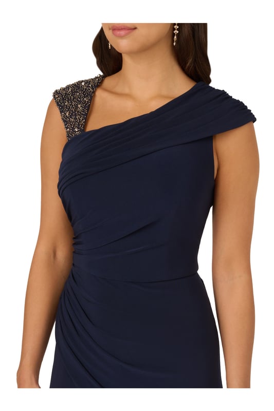 Create a look that sparkles in this wide leg jersey jumpsuit. This jumpsuit features a fitted bodice with shirring at the waist and sleeve, an asymmetrical neckline, and wide legs. Crafted from jersey fabric that has a nice level of stretch for all-night comfort, this jumpsuit is beaded at the shoulder strap. A hidden zipper closure at the centre back completes this dressy jumpsuit. Paired with metallic high heels and sparkling jewellery, this jumpsuit will shine from cocktail attire events to formal weddings.