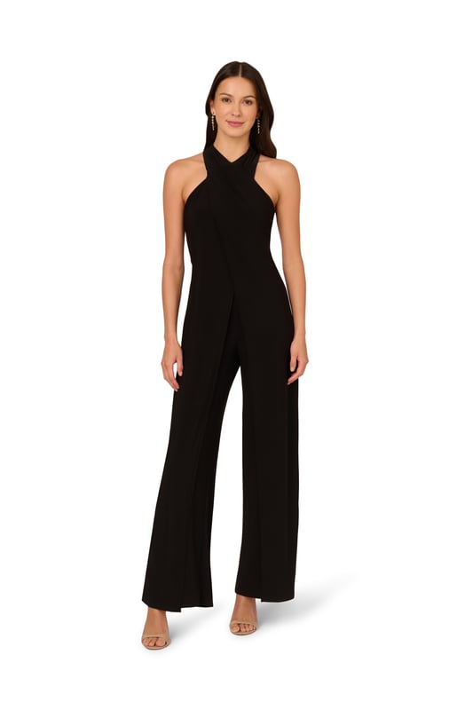 Elevate your wardrobe with this chic black jumpsuit, crafted from luxurious knit jersey fabric for both comfort and style. The halter neckline and sleeveless design exude modern sophistication, while the front fly skirt overlap detail adds a touch of effortless elegance. Finished with a zipper closure at the centre back for a seamless fit, this halter jumpsuit seamlessly blends fashion-forward design with practicality. Perfect for black-tie events or stylish evenings out, this formal jumpsuit for women promises to make a lasting impression with its impeccable craftsmanship and flattering silhouette.
