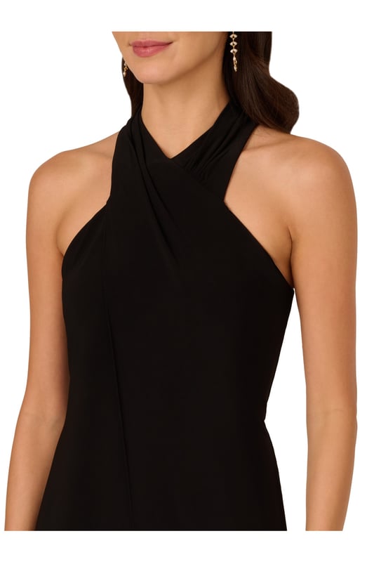 Elevate your wardrobe with this chic black jumpsuit, crafted from luxurious knit jersey fabric for both comfort and style. The halter neckline and sleeveless design exude modern sophistication, while the front fly skirt overlap detail adds a touch of effortless elegance. Finished with a zipper closure at the centre back for a seamless fit, this halter jumpsuit seamlessly blends fashion-forward design with practicality. Perfect for black-tie events or stylish evenings out, this formal jumpsuit for women promises to make a lasting impression with its impeccable craftsmanship and flattering silhouette.