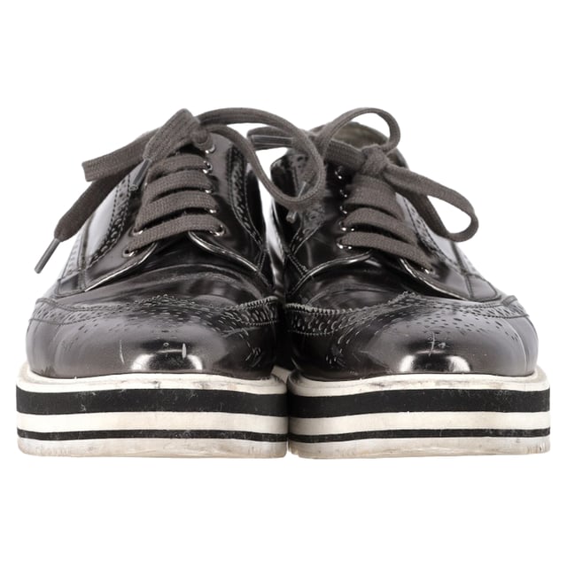 Vintage, Neupreis wie neu  
Bereiten Sie sich darauf vor, Blicke auf sich zu ziehen mit den Prada Metallic Brogue Platform Low Top Sneakers aus silbernem Leder. Diese Sneakers vereinen nahtlos High Fashion und Alltagskomfort. Hergestellt aus luxuriösem metallic Leder, verfügen sie über klassische Wingtip-Brogue-Details und elegante Schnürverschlüsse, die für einen raffinierten, aber lässigen Look sorgen. Die Plattformsohle bietet zusätzliche Höhe und eine einzigartige Note, während die bequemen Einlegesohlen für einen gepolsterten Tragekomfort den ganzen Tag über sorgen. Kombinieren Sie diese Sneakers mit einem plissierten Midirock und einem Blazer für eine unerwartete Mischung aus formell und lässig oder setzen Sie auf einen monochromen Look mit einer silberfarbenen Jacke und maßgeschneiderten Hosen, um das metallische Thema durchgehend zu gestalten.

mit Staubbeutel

Prada Metallic Brogue Platform Low Top Sneakers aus silbernem Leder  
Zustand: Sehr gut  
Tragespuren: Leicht gebraucht, aber sehr gut gepflegt. Kleine Makel an den Sohlen & Faltenbildung, leichte Abnutzung an den Sohlen und Absätzen. Keine sichtbaren Abnutzungsspuren. Kein Makel an der Einlegesohle.  
Verpackung: Staubbeutel  
Farbe: Silber  
Material: Leder | Leder  
Größe: EU | 40,5  
Maße: Absatzhöhe: 50; Einlegesohlenlänge: 290  
SKU: NAPPUGBSH462916W