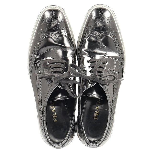Vintage, Neupreis wie neu  
Bereiten Sie sich darauf vor, Blicke auf sich zu ziehen mit den Prada Metallic Brogue Platform Low Top Sneakers aus silbernem Leder. Diese Sneakers vereinen nahtlos High Fashion und Alltagskomfort. Hergestellt aus luxuriösem metallic Leder, verfügen sie über klassische Wingtip-Brogue-Details und elegante Schnürverschlüsse, die für einen raffinierten, aber lässigen Look sorgen. Die Plattformsohle bietet zusätzliche Höhe und eine einzigartige Note, während die bequemen Einlegesohlen für einen gepolsterten Tragekomfort den ganzen Tag über sorgen. Kombinieren Sie diese Sneakers mit einem plissierten Midirock und einem Blazer für eine unerwartete Mischung aus formell und lässig oder setzen Sie auf einen monochromen Look mit einer silberfarbenen Jacke und maßgeschneiderten Hosen, um das metallische Thema durchgehend zu gestalten.

mit Staubbeutel

Prada Metallic Brogue Platform Low Top Sneakers aus silbernem Leder  
Zustand: Sehr gut  
Tragespuren: Leicht gebraucht, aber sehr gut gepflegt. Kleine Makel an den Sohlen & Faltenbildung, leichte Abnutzung an den Sohlen und Absätzen. Keine sichtbaren Abnutzungsspuren. Kein Makel an der Einlegesohle.  
Verpackung: Staubbeutel  
Farbe: Silber  
Material: Leder | Leder  
Größe: EU | 40,5  
Maße: Absatzhöhe: 50; Einlegesohlenlänge: 290  
SKU: NAPPUGBSH462916W