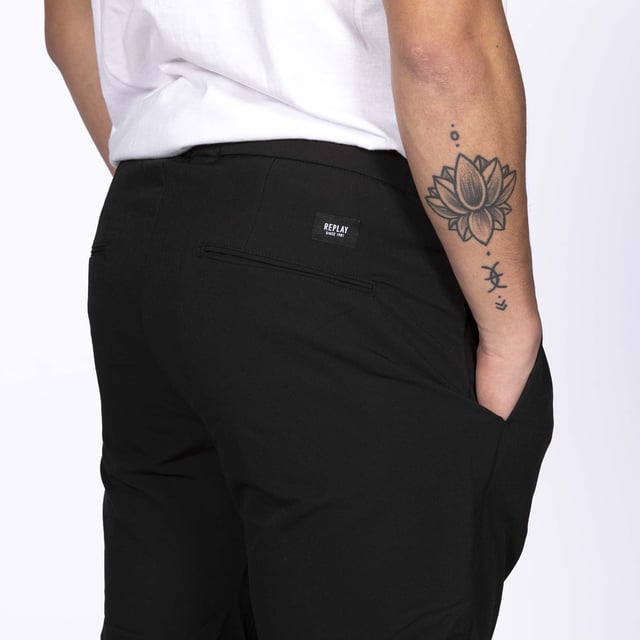 Specificaties: Verstelbare broek met trekkoord aan de binnenkant, zijzakken, gesloten achterzak, Replay-logo aangebracht op de rug en klassieke knoopsluiting Pasvorm: normaal Het model draagt maat: 30 Lengte model: 180 cm
